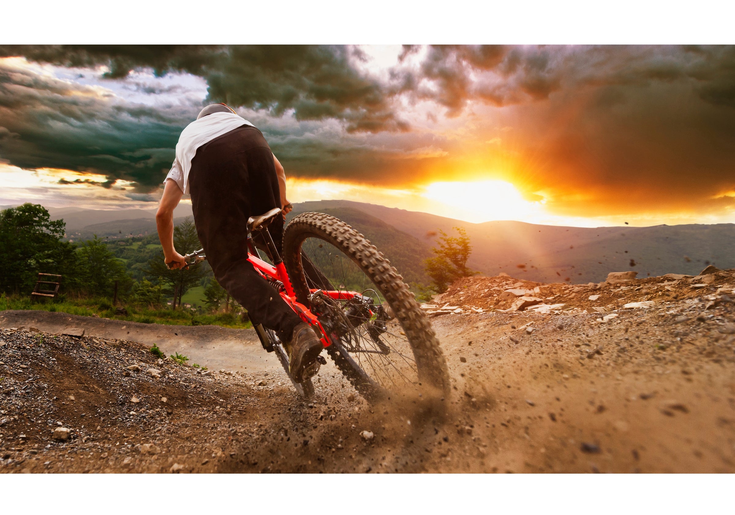 Mountain Biker Skidding on Downhill Trail at Sunset